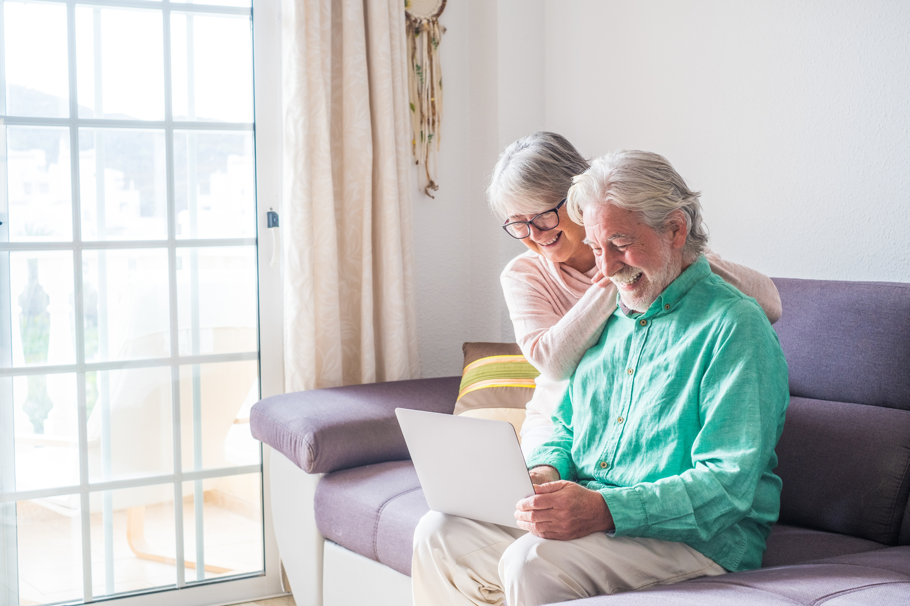 Elderly Couple Using a Laptop in the Living Room